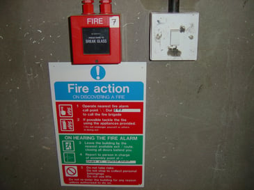 Fire alarm button with instructions underneath, essential for fire alarm maintenance