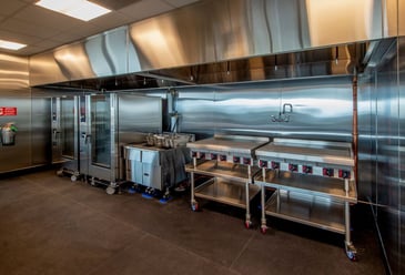Big stainless steel commercial kitchen with fire suppression system installed to save people from fire hazards